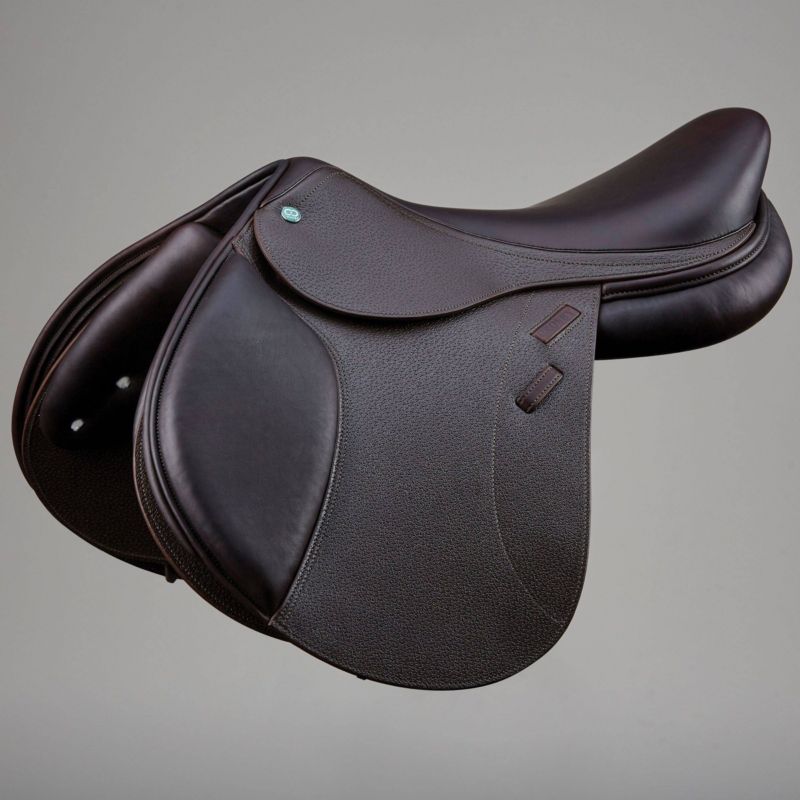 Dark brown Prestige showjumping saddle on grey background.