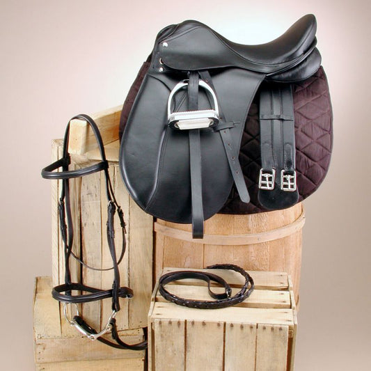 "Black leather dressage saddle with accessories on wooden crates."